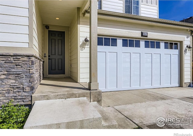 6645 Dry Fork Dr, Frederick, CO 80516 - view of exterior entry with a garage and stone siding