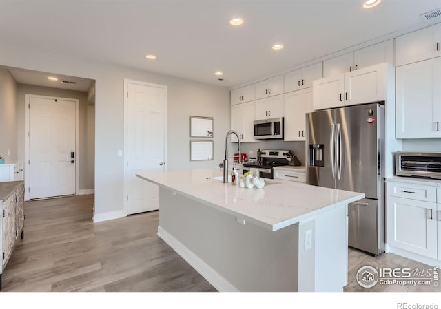 6645 Dry Fork Dr, Frederick, CO 80516 - kitchen featuring appliances with stainless steel finishes, white cabinets, recessed lighting, and a kitchen island with sink
