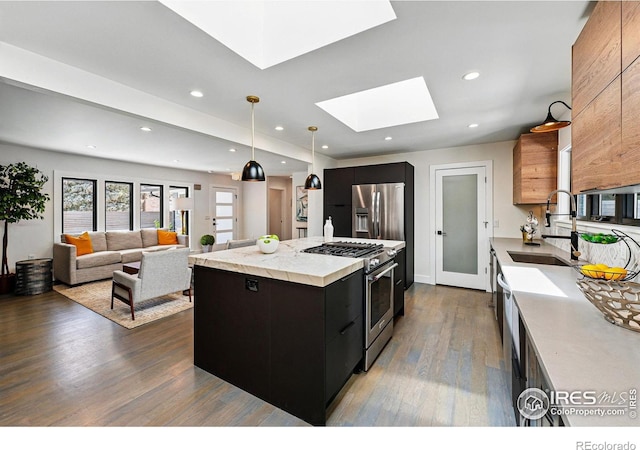 3275 19th St, Boulder, CO 80304 - kitchen featuring appliances with stainless steel finishes, modern cabinets, dark cabinetry, a skylight, and light countertops