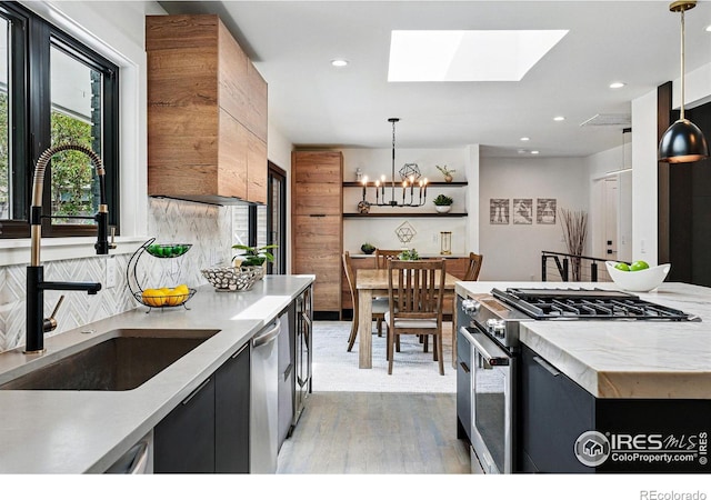 3275 19th St, Boulder, CO 80304 - kitchen with stainless steel appliances, a chandelier, light countertops, light wood finished floors, and pendant lighting