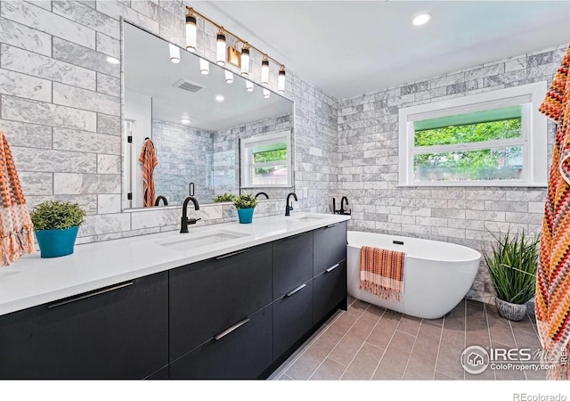 3275 19th St, Boulder, CO 80304 - bathroom featuring tile walls, healthy amount of natural light, double vanity, tile patterned floors, and a freestanding bath