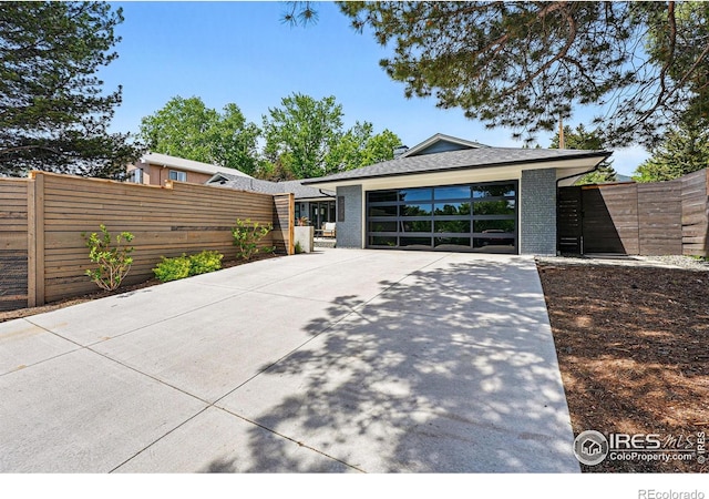 3275 19th St, Boulder, CO 80304 - view of front of home with brick siding, concrete driveway, roof with shingles, and a garage