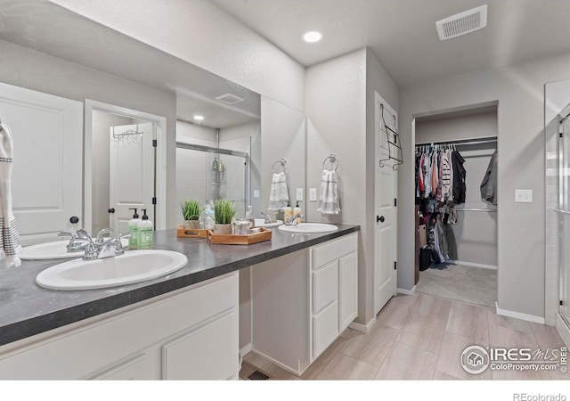 3644 Ronald Reagan Ave, Wellington, CO 80549 - full bathroom featuring a stall shower, double vanity, a walk in closet, and recessed lighting