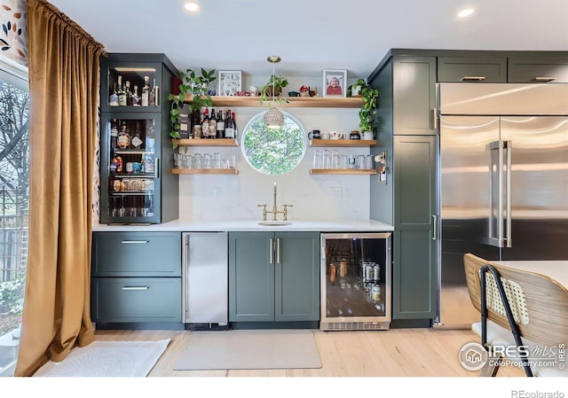 1405 Clover Creek Dr, Longmont, CO 80503 - indoor wet bar featuring wine cooler, stainless steel built in refrigerator, fridge, light wood-style flooring, and recessed lighting