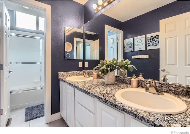 1405 Clover Creek Dr, Longmont, CO 80503 - bathroom with double vanity, tile patterned flooring, enclosed tub / shower combo, and a textured wall
