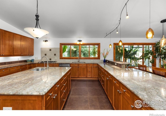 108 Lonestar Rd, Lyons, CO 80540 - kitchen featuring brown cabinetry, light stone countertops, dark tile patterned floors, and decorative light fixtures