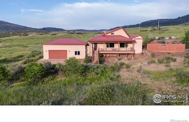 108 Lonestar Rd, Lyons, CO 80540 - view of front of home featuring stairs, stucco siding, a garage, a metal roof, and a mountain view