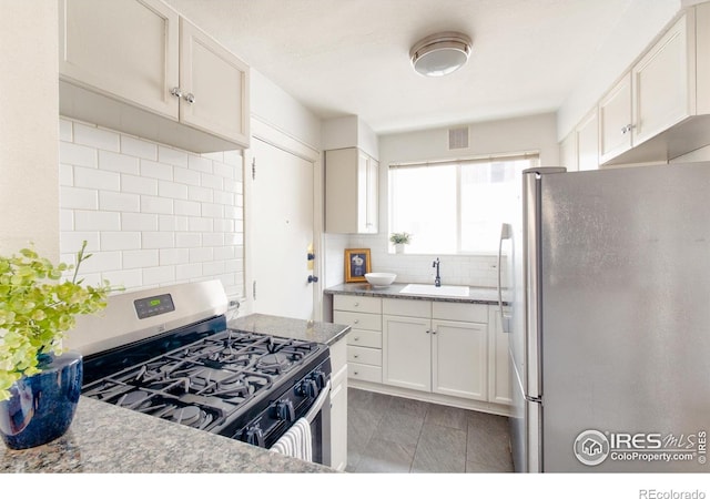 1100 Colorado Blvd Unit 305, Denver, CO 80206 - kitchen featuring appliances with stainless steel finishes, tasteful backsplash, and white cabinetry