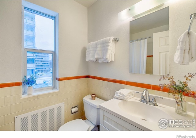 1100 Colorado Blvd Unit 305, Denver, CO 80206 - full bath featuring radiator, plenty of natural light, tile walls, vanity, and wainscoting