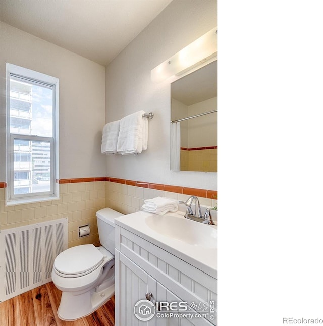 1100 Colorado Blvd Unit 305, Denver, CO 80206 - full bath featuring radiator heating unit, tile walls, vanity, wainscoting, and wood finished floors