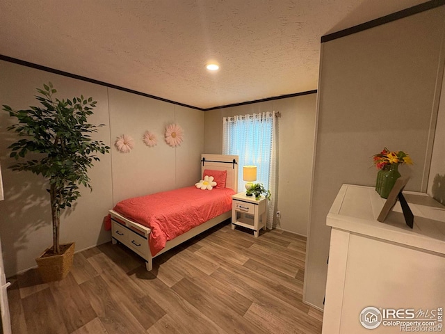 48990 County Road 41, Nunn, CO 80648 - bedroom with ornamental molding, light wood-type flooring, and a textured ceiling