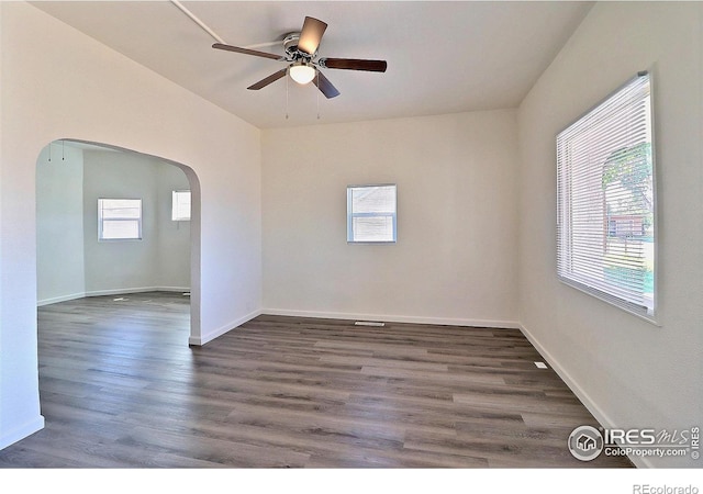 263 E 2nd St, Ault, CO 80610 - empty room featuring arched walkways, a ceiling fan, and dark wood finished floors