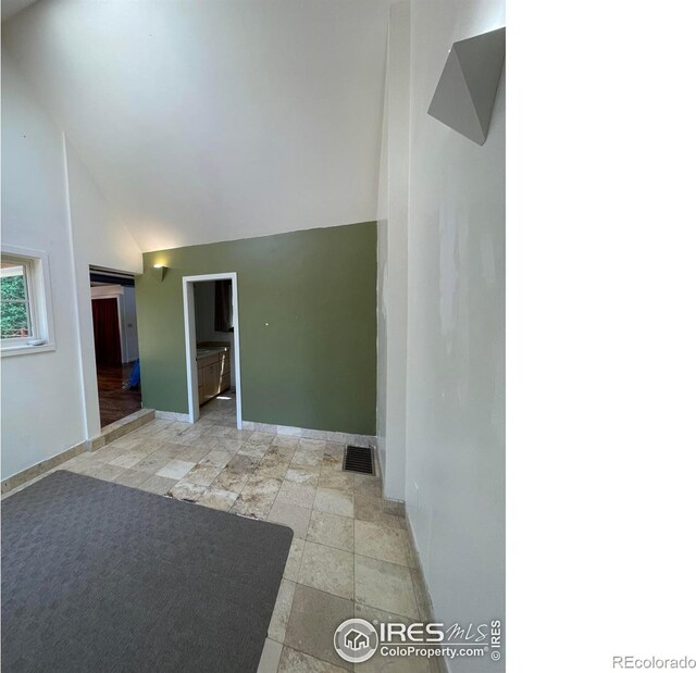383 Evergreen Rd, Black Hawk, CO 80422 - empty room featuring light stone finish floors and high vaulted ceiling