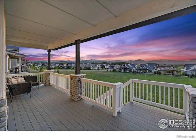 3315 Heron Lakes Pkwy, Berthoud, CO 80513 - deck at dusk featuring a residential view and a lawn