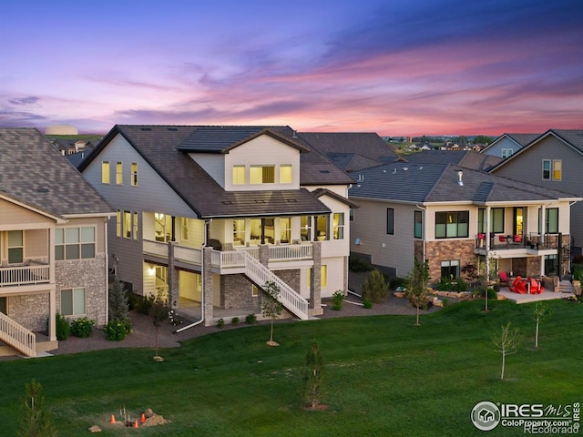 3315 Heron Lakes Pkwy, Berthoud, CO 80513 - rear view of property featuring stairs, a patio, a yard, and a balcony