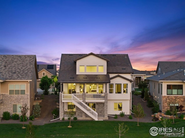 3315 Heron Lakes Pkwy, Berthoud, CO 80513 - back of property at dusk featuring stairway, a yard, and a porch