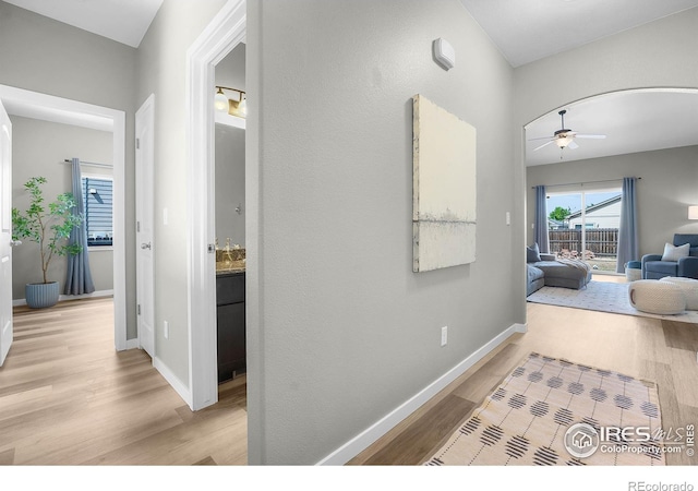 1384 S Growers Dr, Milliken, CO 80543 - hall with light wood-style flooring and arched walkways
