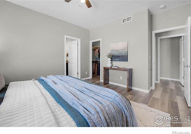1384 S Growers Dr, Milliken, CO 80543 - bedroom featuring wood finished floors, a walk in closet, a closet, and a ceiling fan