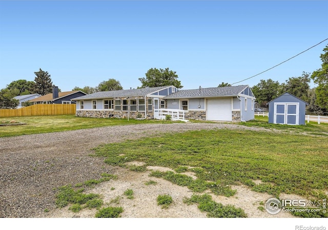 4331 Page Pl, Loveland, CO 80537 - view of front of house with stone siding, an attached garage, a shed, and driveway