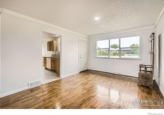 4331 Page Pl, Loveland, CO 80537 - unfurnished living room featuring a textured ceiling, wood-type flooring, crown molding, and recessed lighting