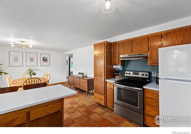 2306 Ptelea Ct, Loveland, CO 80538 - kitchen featuring freestanding refrigerator, stainless steel range with electric stovetop, under cabinet range hood, tasteful backsplash, and light countertops