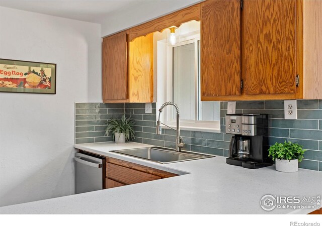 2306 Ptelea Ct, Loveland, CO 80538 - kitchen with dishwasher, light countertops, tasteful backsplash, and brown cabinetry