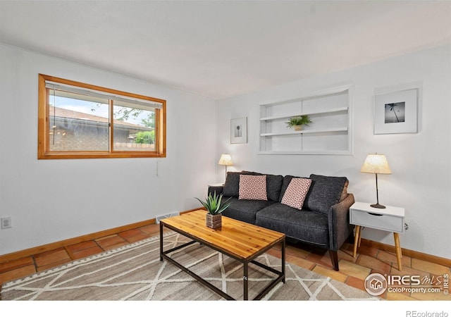 2306 Ptelea Ct, Loveland, CO 80538 - tiled living room featuring built in shelves and baseboards