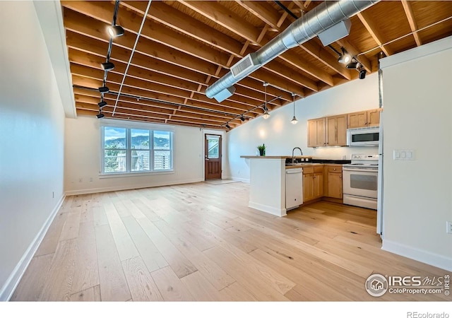1941 Pearl St Unit 303, Boulder, CO 80302 - kitchen with white appliances, a peninsula, open floor plan, and light wood-type flooring