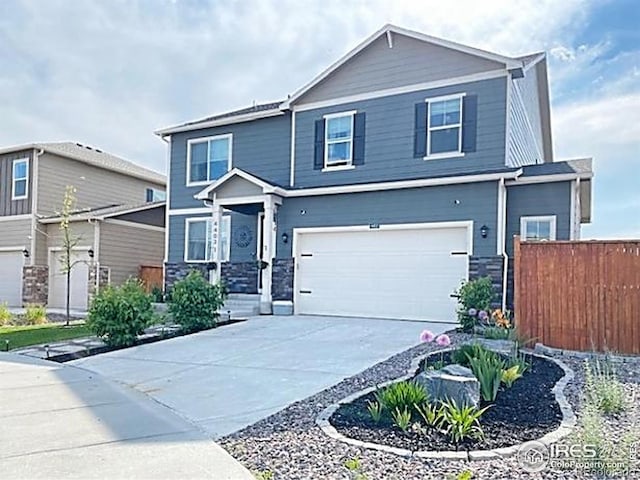 4403 Garnet Way, Longmont, CO 80504 - view of front facade with concrete driveway, stone siding, and an attached garage