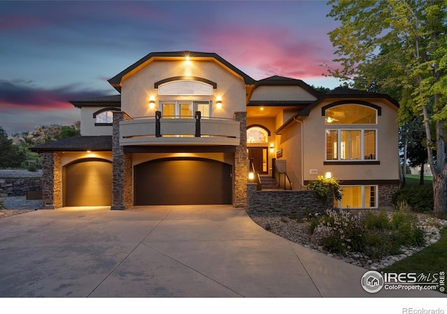 4926 Saint Andrews Ct, Loveland, CO 80537 - view of front facade with a balcony, stucco siding, a garage, driveway, and stone siding
