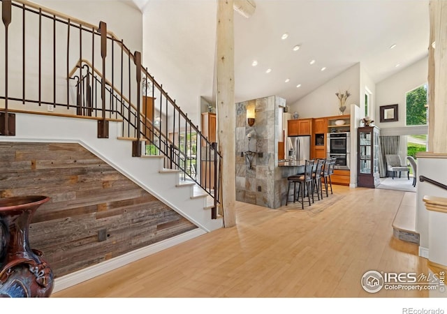 4926 Saint Andrews Ct, Loveland, CO 80537 - stairs with high vaulted ceiling, wood finished floors, and recessed lighting