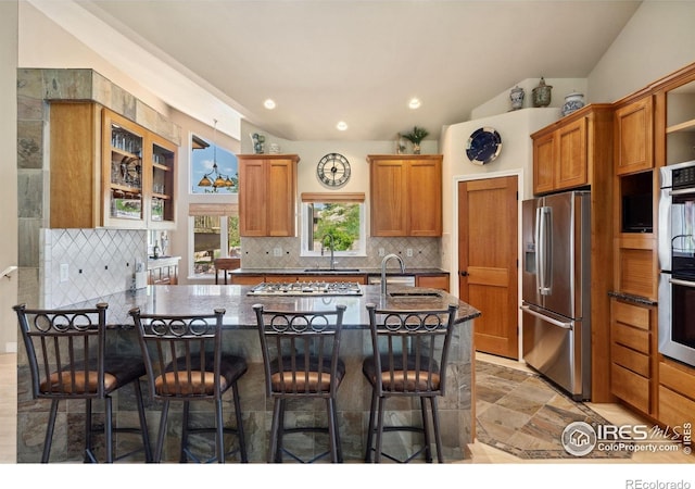 4926 Saint Andrews Ct, Loveland, CO 80537 - kitchen with appliances with stainless steel finishes, tasteful backsplash, brown cabinets, and recessed lighting