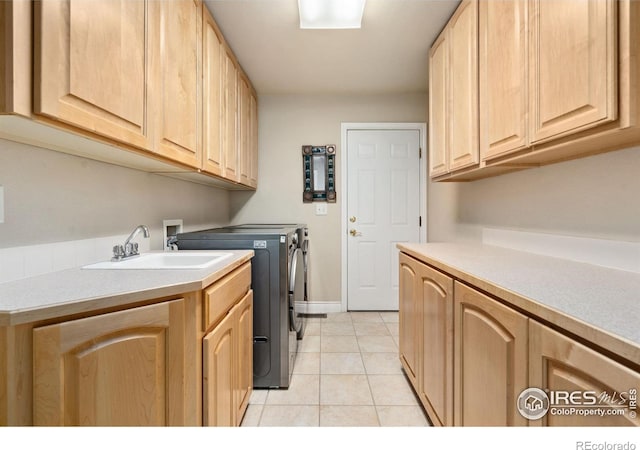 4926 Saint Andrews Ct, Loveland, CO 80537 - washroom featuring washer and clothes dryer, cabinet space, and light tile patterned floors