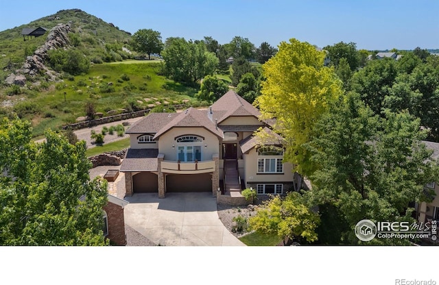 4926 Saint Andrews Ct, Loveland, CO 80537 - view of front of home featuring a garage, stucco siding, driveway, and stone siding