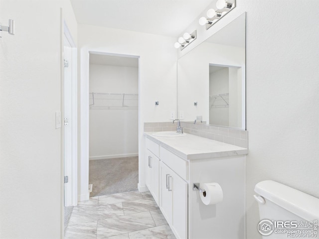 3840 Katmai Ave, Evans, CO 80620 - bathroom with marble look tile flooring, vanity, and a walk in closet