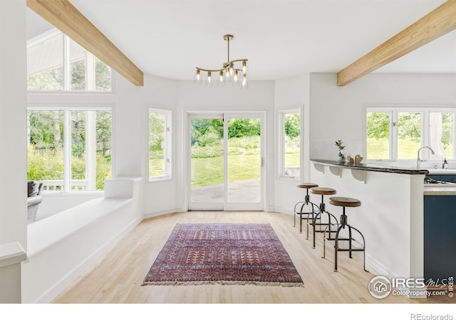 3421 4th St, Boulder, CO 80304 - kitchen featuring beam ceiling, plenty of natural light, light wood-style flooring, a kitchen bar, and a chandelier