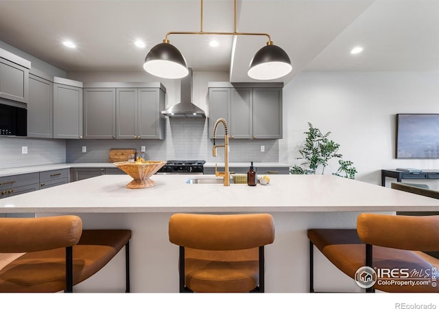 648 Greenspire Dr Unit 6, Windsor, CO 80550 - kitchen with gray cabinets, wall chimney exhaust hood, a breakfast bar, backsplash, and light countertops
