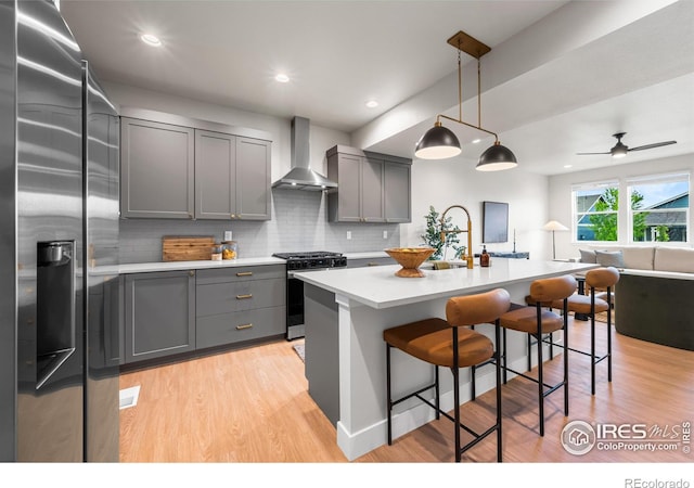 648 Greenspire Dr Unit 6, Windsor, CO 80550 - kitchen featuring stainless steel appliances, wall chimney range hood, gray cabinets, light countertops, and light wood finished floors