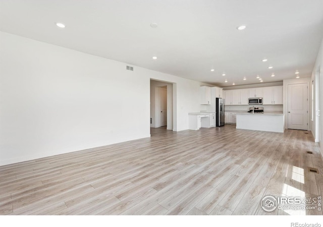 5226 Inland Ave, Firestone, CO 80504 - unfurnished living room with recessed lighting and light wood-type flooring