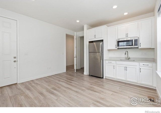 5226 Inland Ave, Firestone, CO 80504 - kitchen with stainless steel appliances, light wood-style flooring, light countertops, white cabinetry, and recessed lighting