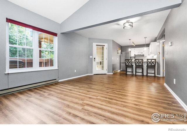 3531 Windmill Dr Unit 3, Fort Collins, CO 80526 - unfurnished living room with lofted ceiling, wood finished floors, and a baseboard radiator