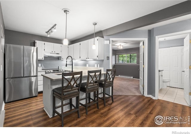 3531 Windmill Dr Unit 3, Fort Collins, CO 80526 - kitchen with freestanding refrigerator, under cabinet range hood, white cabinets, dark wood-style floors, and hanging light fixtures