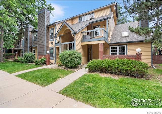 3531 Windmill Dr Unit 3, Fort Collins, CO 80526 - view of front of property featuring a balcony, a chimney, a front yard, and brick siding