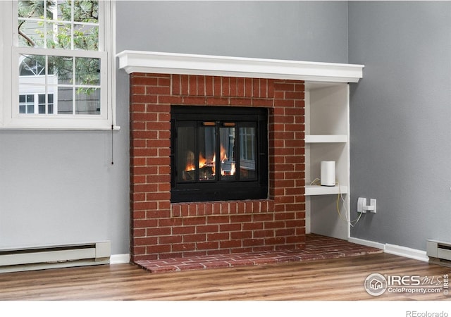 3531 Windmill Dr Unit 3, Fort Collins, CO 80526 - detailed view of a baseboard heating unit, wood finished floors, and a glass covered fireplace