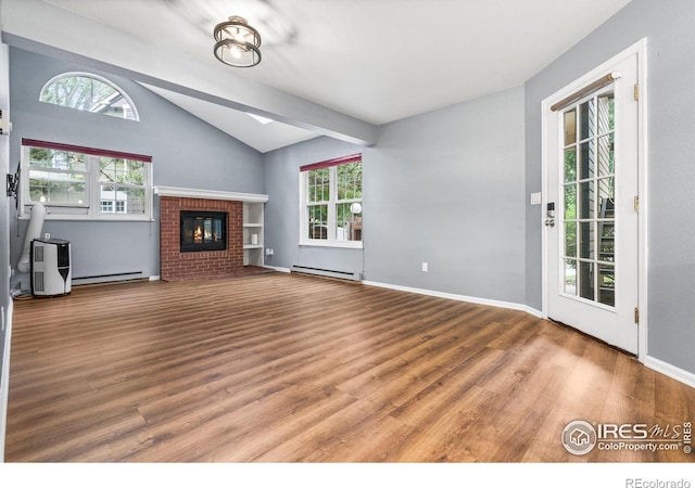 3531 Windmill Dr Unit 3, Fort Collins, CO 80526 - unfurnished living room featuring baseboard heating, vaulted ceiling, wood finished floors, and a brick fireplace