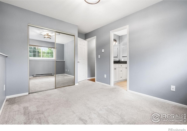 3531 Windmill Dr Unit 3, Fort Collins, CO 80526 - unfurnished bedroom featuring a baseboard heating unit, light carpet, a closet, and connected bathroom