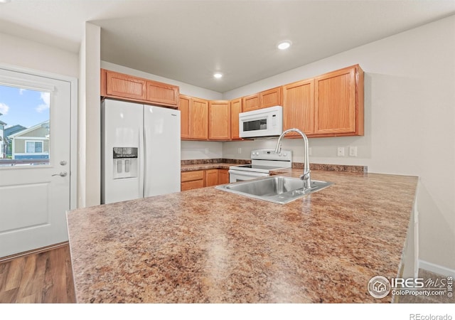 67 Quail Rd, Longmont, CO 80501 - kitchen featuring white appliances, a peninsula, wood finished floors, light countertops, and recessed lighting