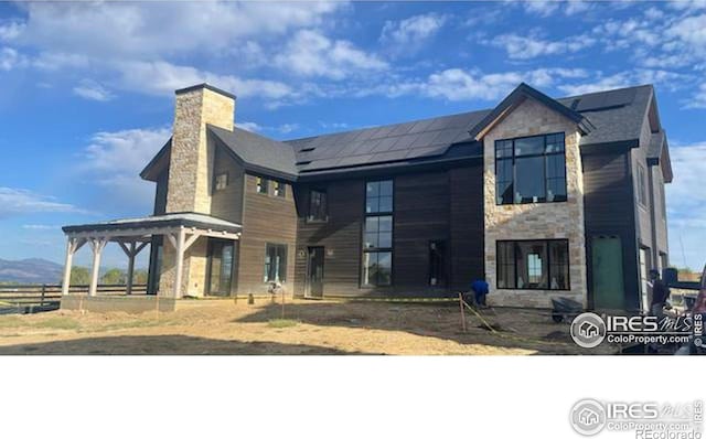 917 Latigo Loop, Lafayette, CO 80026 - modern home featuring stone siding, solar panels, and a chimney