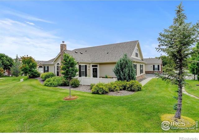 2421 Santa Fe Dr Unit B, Longmont, CO 80504 - back of property with a chimney, a lawn, and a shingled roof