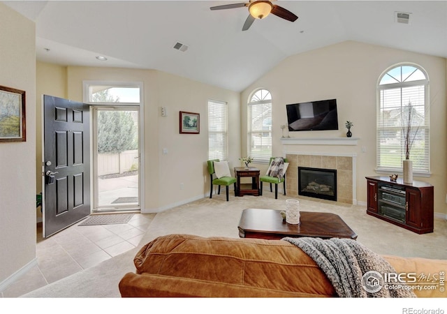 2421 Santa Fe Dr Unit B, Longmont, CO 80504 - living room featuring a ceiling fan, a tile fireplace, vaulted ceiling, light colored carpet, and light tile patterned flooring